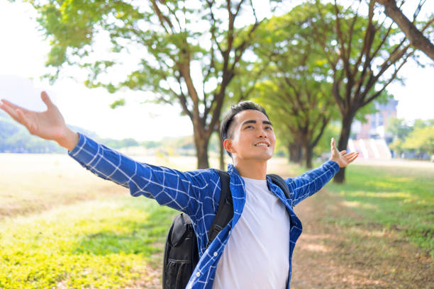 istock Happy man breathing deeply fresh air in a forest with green trees 1354984956
