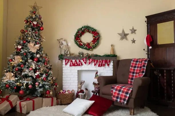 Living room and fireplace decorated with large Christmas tree