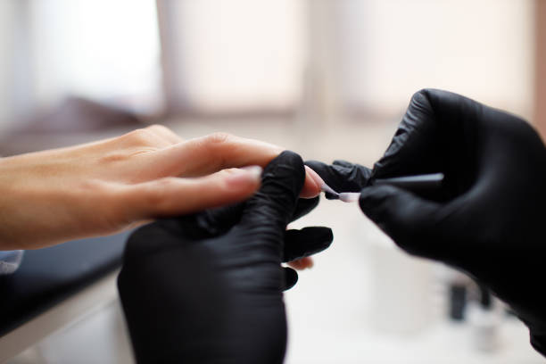 istock Manicure process female hands finger nails polish 1354989819