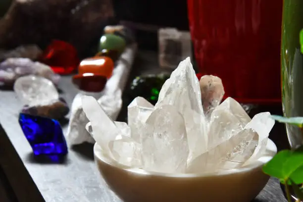 An image of a marble bowl filled with a variety of clear quartz crystals.