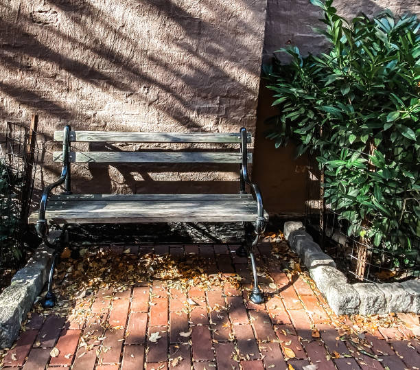 istock Wooden bench in front of brick wall 1354993697