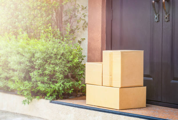Cardboard boxes on the doorstep Cardboard boxes on the doorstep home delivery doorstep stock pictures, royalty-free photos & images