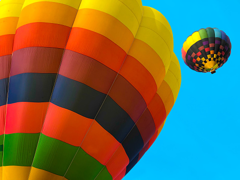 Taos, NM: Two hot air balloons high in a turquoise sky at the annual Taos Balloon Fiesta.