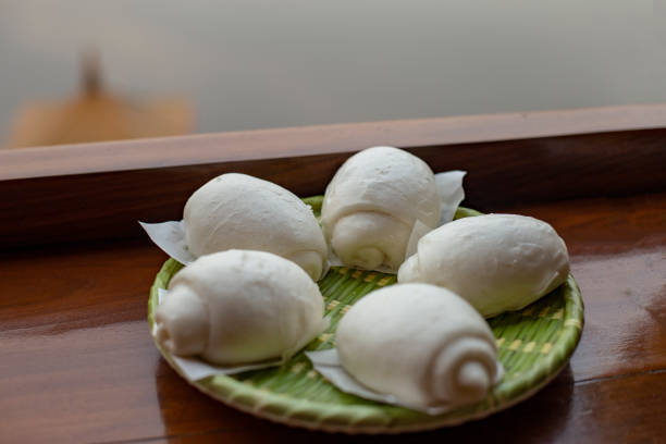 Mantou on a green plate placed on a wooden table.