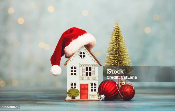 House With Santa Hat And Christmas Tree And Holiday Decorations Home For The Holidays Theme Stock Photo - Download Image Now
