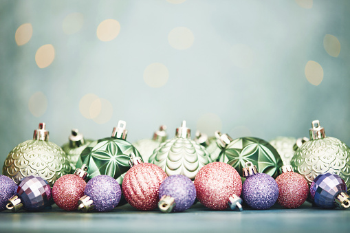 Christmas background with pastel colored glittery Christmas ornaments and Christmas lights. Christmas background with copy space