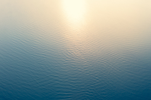 Vista aérea de una textura cristalina de agua de mar. Vista desde arriba Fondo azul natural. Reflejo de agua azul. Ola azul del océano al atardecer. Mar de verano. Vista superior photo