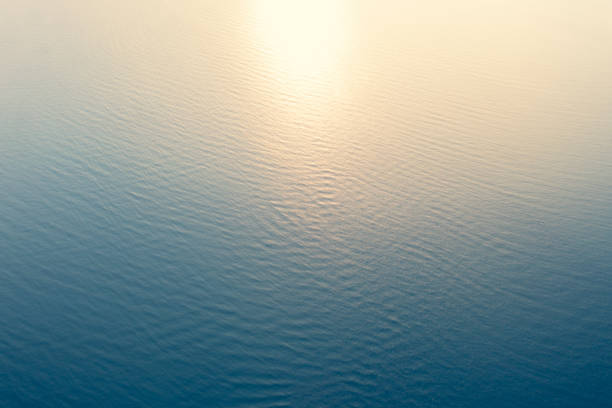 Aerial view of a crystal clear sea water texture. View from above Natural blue background. Blue water reflection. Blue ocean wave at the sunset. Summer sea. Top view stock photo
