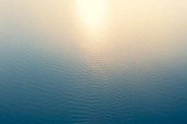 Photo of Aerial view of a crystal clear sea water texture. View from above Natural blue background. Blue water reflection. Blue ocean wave at the sunset. Summer sea. Top view