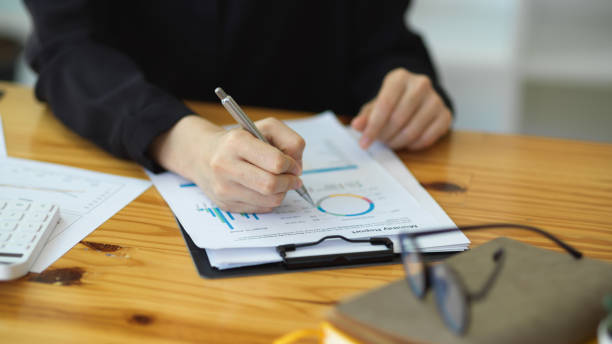 istock Businesswoman taking a notes on financial paperwork. 1355015563