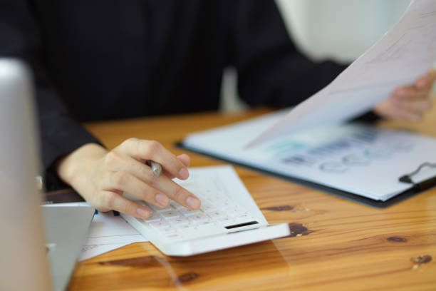 istock Businesswoman using calculator and working with financial report. 1355015654