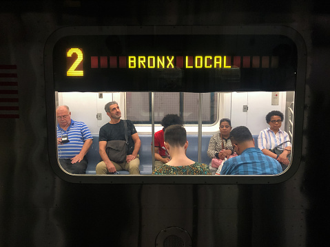 New York, USA - June 6, 2019: People on the number 2 bronx local subway late in the day.