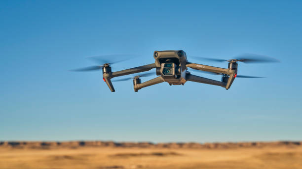 DJI foldable Mavic 3 drone flying over prairie stock photo