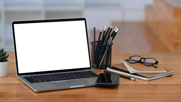 istock Computer laptop, smart phone, pencil holder and books on wooden table. 1355024532