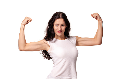 Happy young woman shows her muscles isolated on white background. Strength and power concept