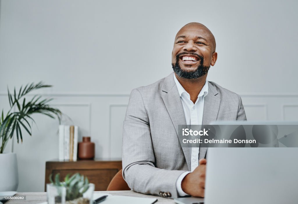 Shot of a mature businessman using a laptop in a modern office I see it and I like it Men Stock Photo