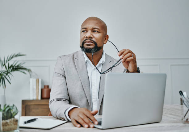 Shot of a mature businessman using a laptop in a modern office A dream should never be just that critical thinking pics stock pictures, royalty-free photos & images