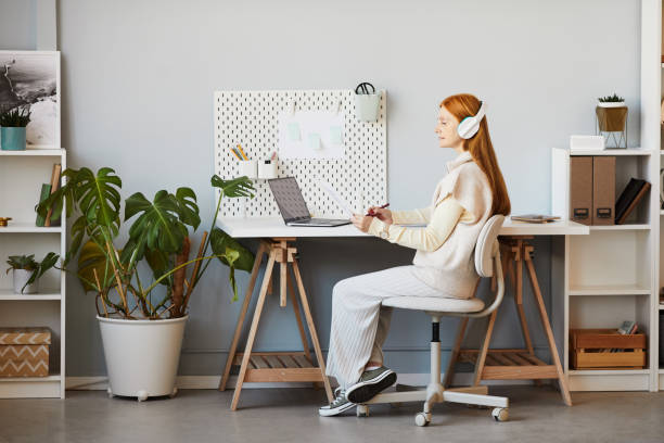 홈 오피스에서 일하는 빨간 머리 의 여자 - mature adult home interior chair contemporary 뉴스 사진 이미지