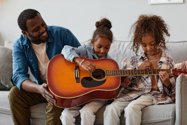 istock Girls Playing with Guitar 1355035026