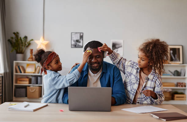 istock Daughters Playing with Father in Online Meeting 1355035190