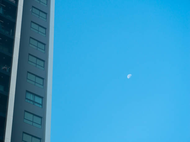 istock Moon Appears in The Daytime beside The Modern Building 1355035500