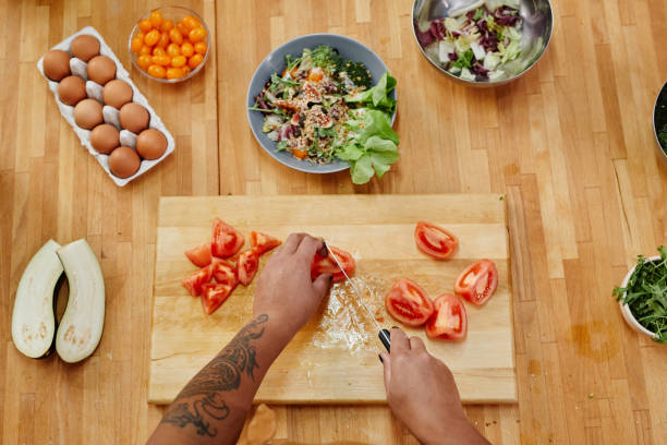istock Tattooed Woman Cutting Vegetables 1355035538
