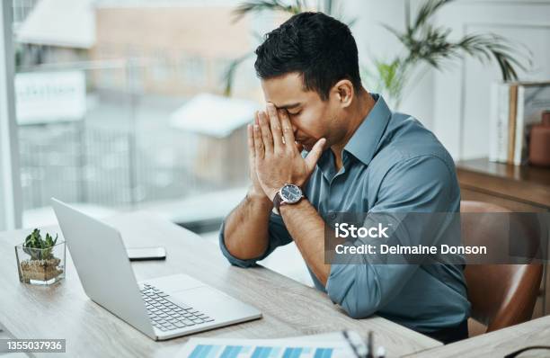 Shot Of A Young Businessman Looking Stressed While Working In A Modern Office Stock Photo - Download Image Now