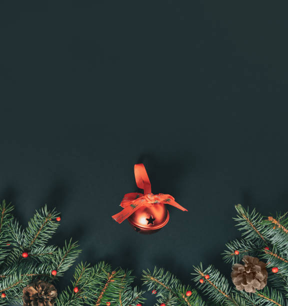 istock Pine twigs, pine cones, red berries and red decoration ball lay down on black background. Minimal flat lay vertical composition, Christmas and New Year elegant decorative  concept with copy space 1355038021