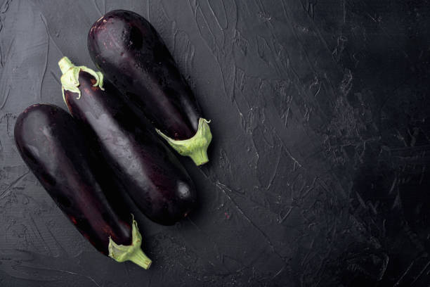 istock Fresh organic eggplant, on black stone background, top view flat lay, with copy space for text 1355039036