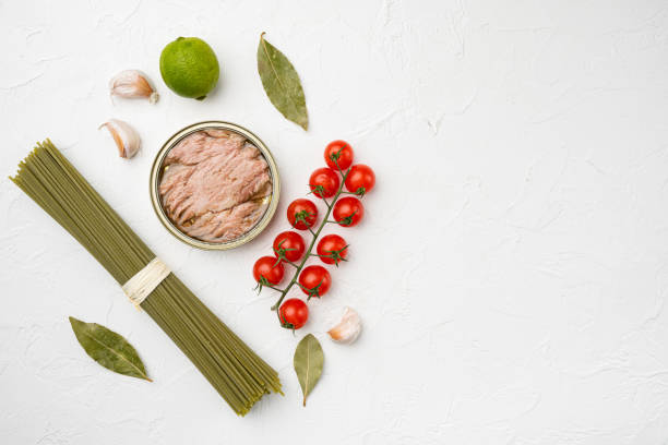 istock Uncooked Pasta with vegetables and tuna ingredients, on white stone table background, top view flat lay, with copy space for text 1355039141