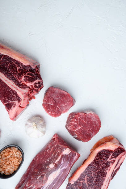 fresh raw prime black angus beef marbled and dry aged steaks, tomahawk, t bone, club steak, rib eye and tenderloin cuts, on white stone  background, top view flat lay, with copy space for text - veal t bone steak raw steak imagens e fotografias de stock