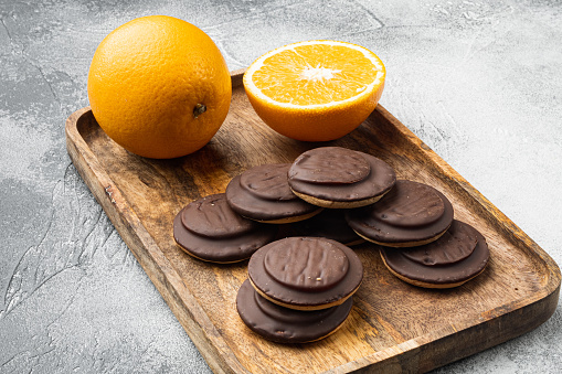 Jaffa Cakes. Cookies covered with dark chocolate and filled with orange marmalade set, on gray background