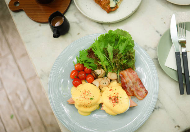 istock Breakfast Eggs Benedict toasted English muffins. Delicious breakfast with eggs Benedict 1355040415