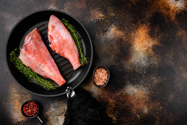 istock Fish raw snapper, in frying cast iron pan, on old dark rustic table background, top view flat lay, with copy space for text 1355040524