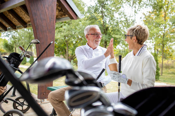 pozytywni seniorzy gotowi do treningu golfowego. - golf green practicing sports training zdjęcia i obrazy z banku zdjęć