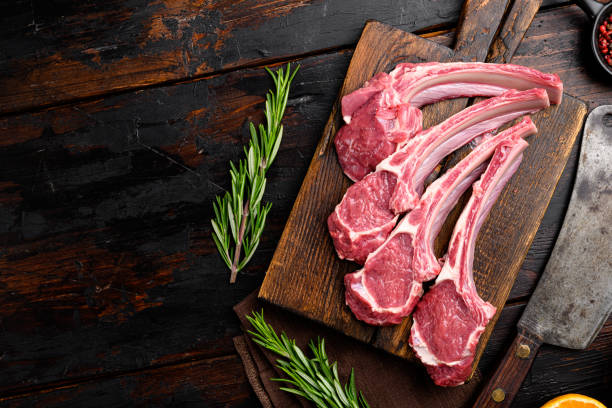 istock Raw lamb meat chops steaks, on old dark  wooden table background, top view flat lay, with copy space for text 1355043242