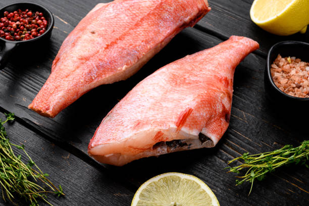 istock Red sea perch raw whole fresh fish, on black wooden table background 1355045975