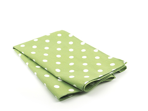 White polka dot on green fabric or napkin isolated on white background. Concept kitchen utensils and tableware.