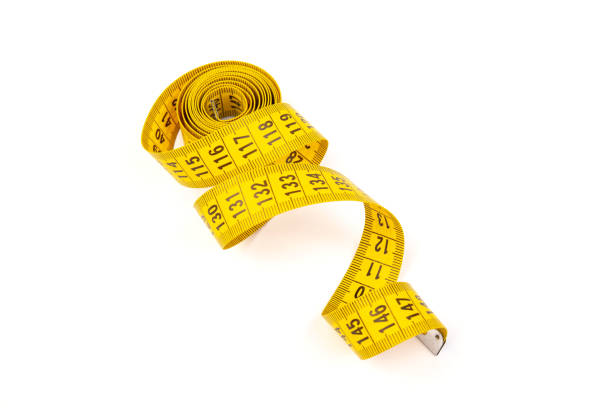 istock Yellow measuring tape spiral, isolated on white background. 1355046172