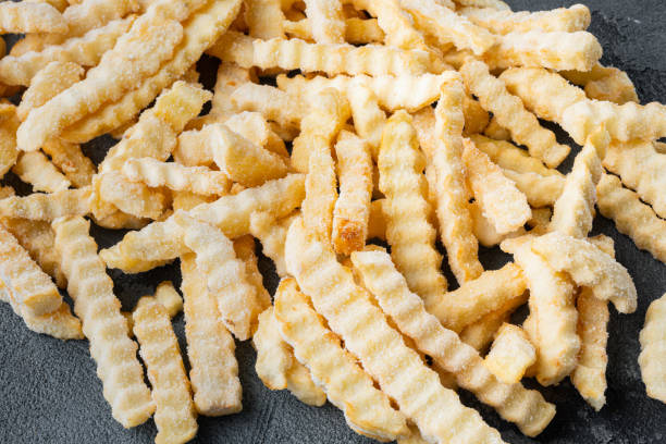 istock Frozen oven chips sliced potato, on gray background 1355046232
