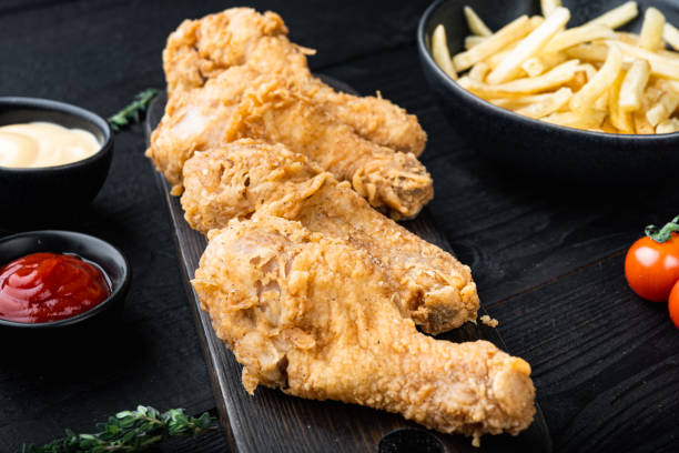 istock Fried crispy chicken legs, drumstick  on black wooden background 1355047163
