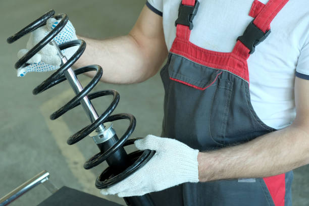 pezzi di ricambio per l'auto. la molla e il montante dell'ammortizzatore sono nelle mani di un meccanico d'auto. - shock absorber foto e immagini stock