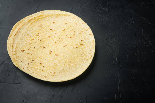 Fresh yellow corn tortillas, on black background with copy space for text
