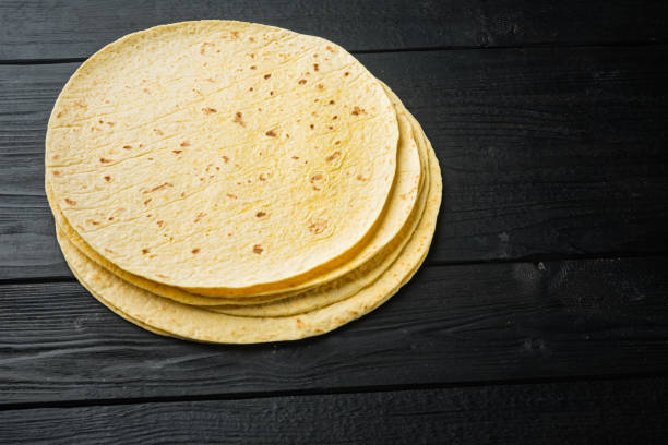 istock Mexican corn tortillas, on black wooden table background  with copy space for text 1355048813