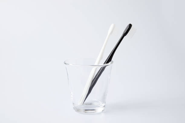 white black toothbrushes in glass toiletries isolated on white background - 3615 imagens e fotografias de stock