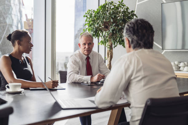 istock Corporate team conversing in modern board room 1355051099