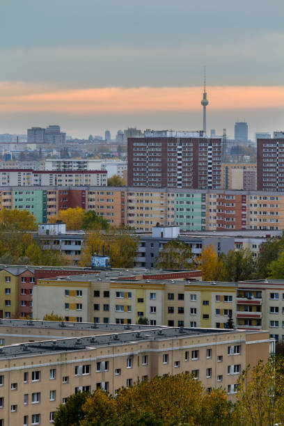 blick vom hügel über die dächer ost-berlins bei sonnenuntergang mit fernsehturm im hintergrund - plattenbau berlin germany east germany office building stock-fotos und bilder