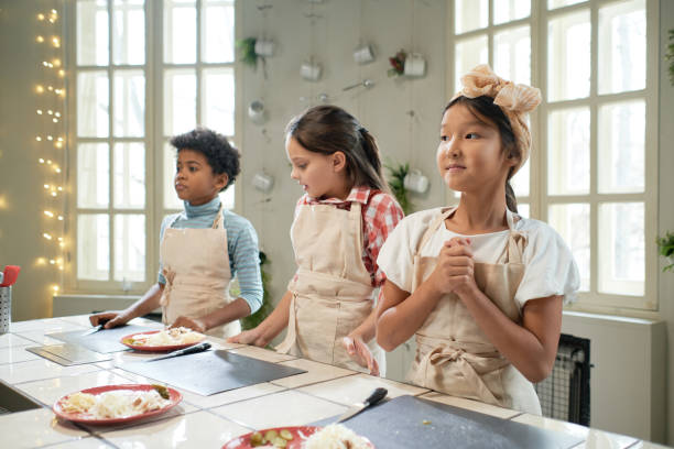 istock Children standing at cooking lesson 1355052605