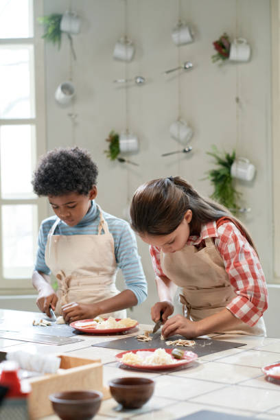istock Children cutting vegetables for pizza 1355052613