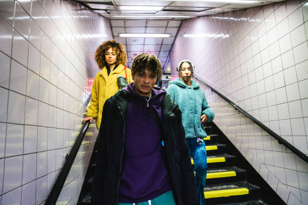 istock Three friends coming down the stairs in subway 1355054579